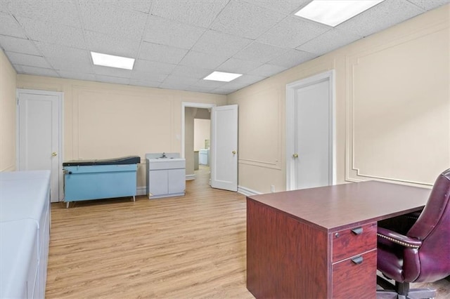 office with a paneled ceiling and light wood-type flooring