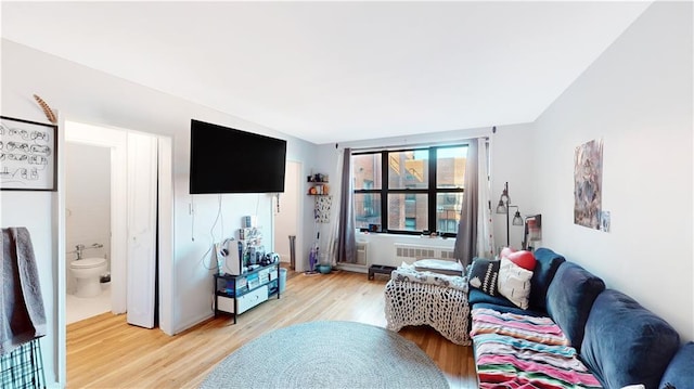 living room featuring light wood-style flooring and radiator heating unit