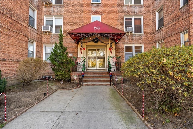 entrance to property featuring french doors, cooling unit, and brick siding