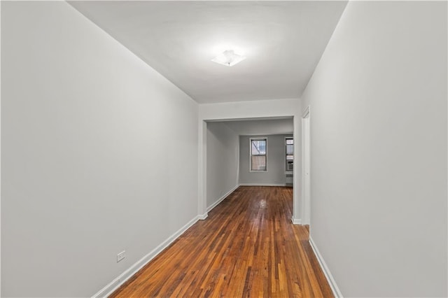 hall featuring baseboards and hardwood / wood-style floors