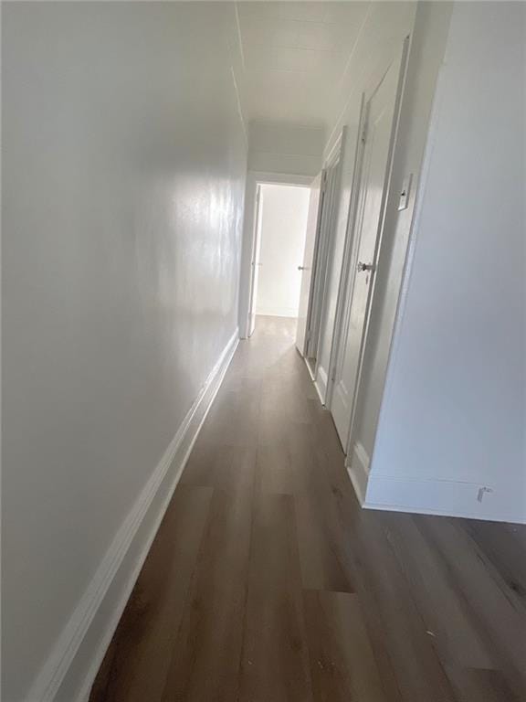 hall with baseboards and dark wood-style floors