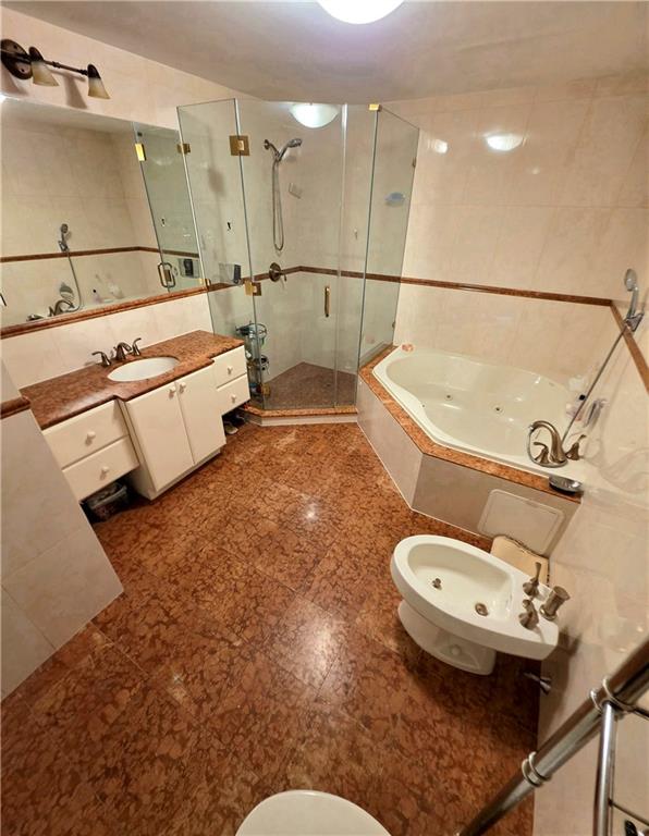 1927 78th St Unit 4A, Brooklyn, NY 11214 - bathroom featuring a shower stall, a jetted tub, vanity, a bidet, and tile walls
