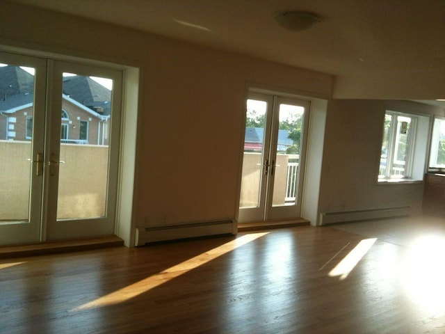 doorway to outside with a baseboard radiator, a baseboard heating unit, wood finished floors, and french doors