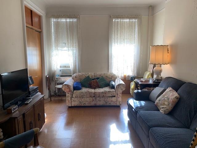 living room featuring cooling unit and dark parquet floors