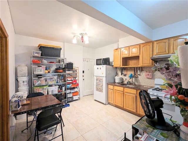 kitchen featuring an inviting chandelier, white fridge, decorative backsplash, light tile patterned floors, and exhaust hood