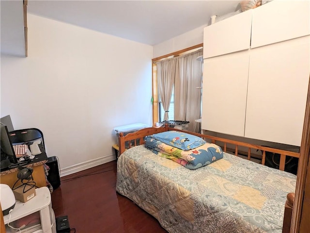 bedroom with dark hardwood / wood-style floors