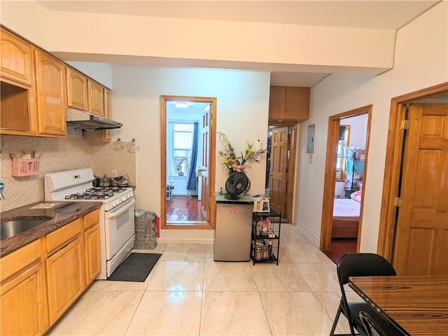 kitchen featuring tasteful backsplash, white gas range, and sink