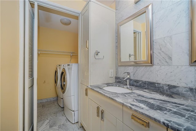 bathroom with marble finish floor, separate washer and dryer, a closet, and vanity