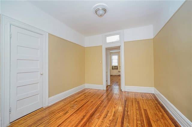 spare room featuring hardwood / wood-style floors and baseboards