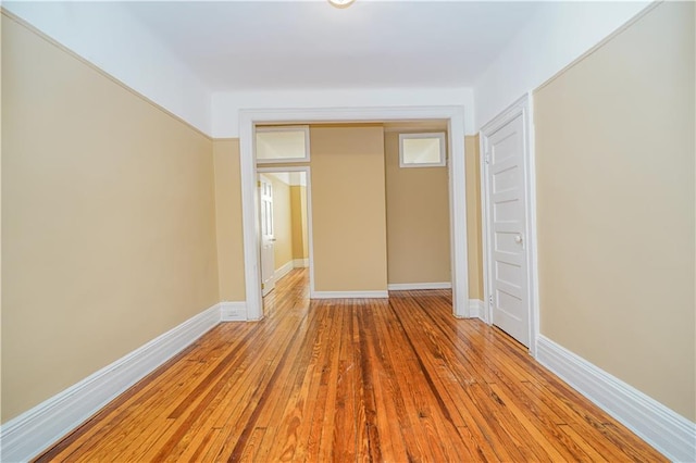 unfurnished bedroom featuring a closet, light wood-style flooring, and baseboards