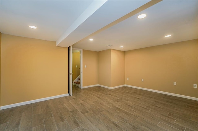 finished below grade area featuring stairs, recessed lighting, wood finished floors, and baseboards