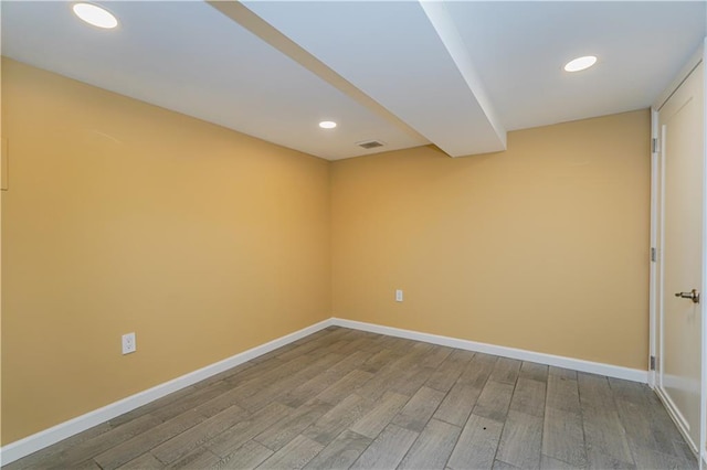 empty room featuring visible vents, baseboards, wood finished floors, and recessed lighting