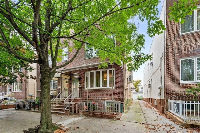 view of front of house with brick siding and fence