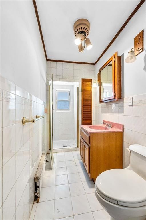 bathroom with a shower stall, tile walls, crown molding, and toilet