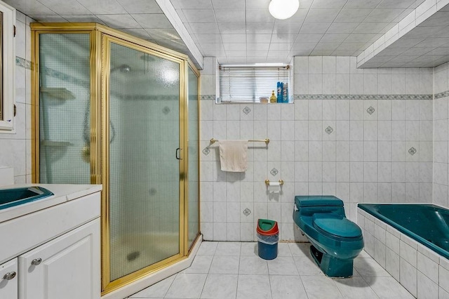 bathroom featuring toilet, tile walls, a shower stall, tile patterned flooring, and vanity