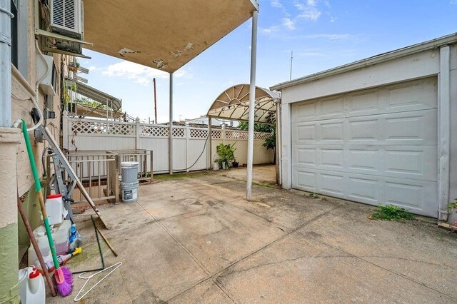 view of patio with an outbuilding and a garage