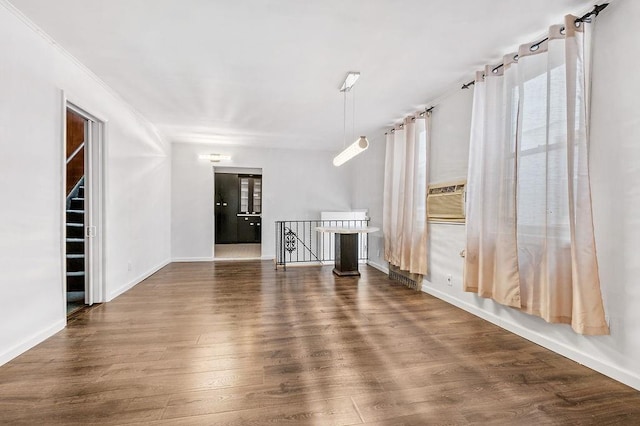 spare room with cooling unit, wood finished floors, and baseboards