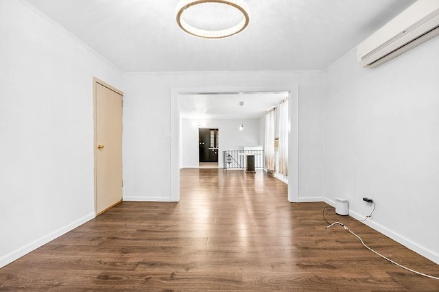 unfurnished room featuring wood finished floors, baseboards, a wall mounted air conditioner, and ornamental molding