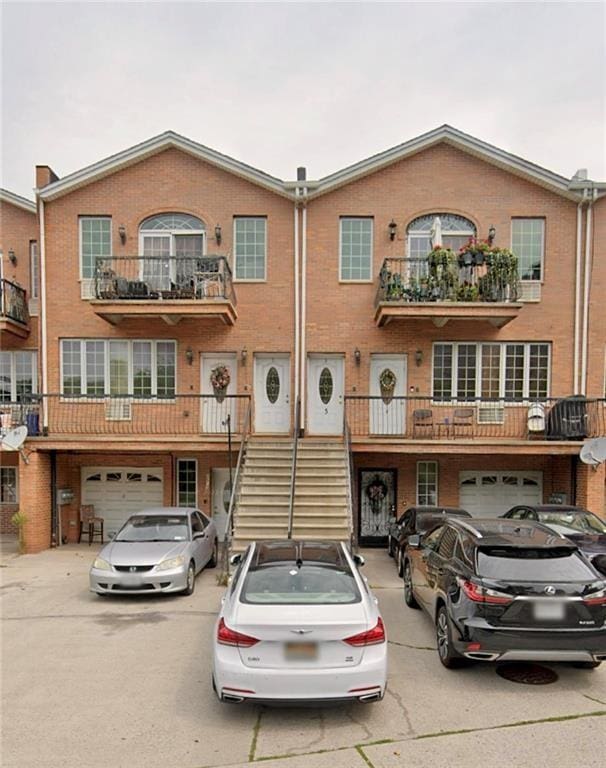 2613 Shore Pkwy, Brooklyn, NY 11223 - townhome / multi-family property with driveway, an attached garage, brick siding, and stairs
