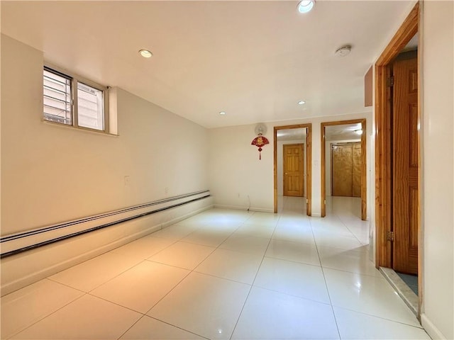 empty room featuring light tile patterned floors, a baseboard radiator, baseboards, and recessed lighting