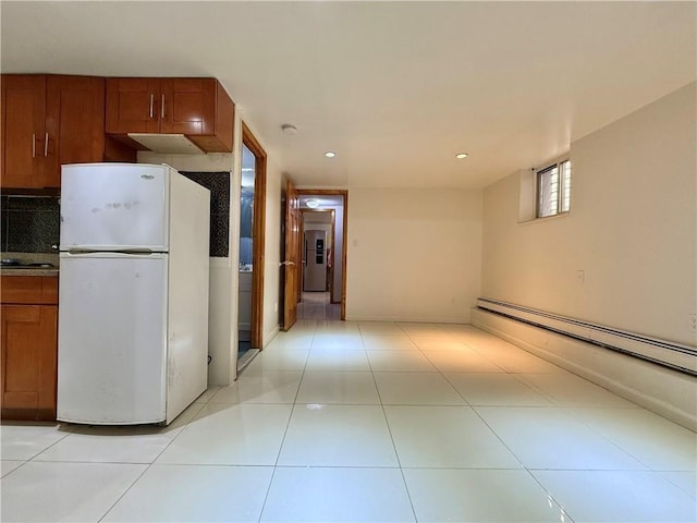 kitchen with light tile patterned floors, recessed lighting, baseboard heating, freestanding refrigerator, and brown cabinetry