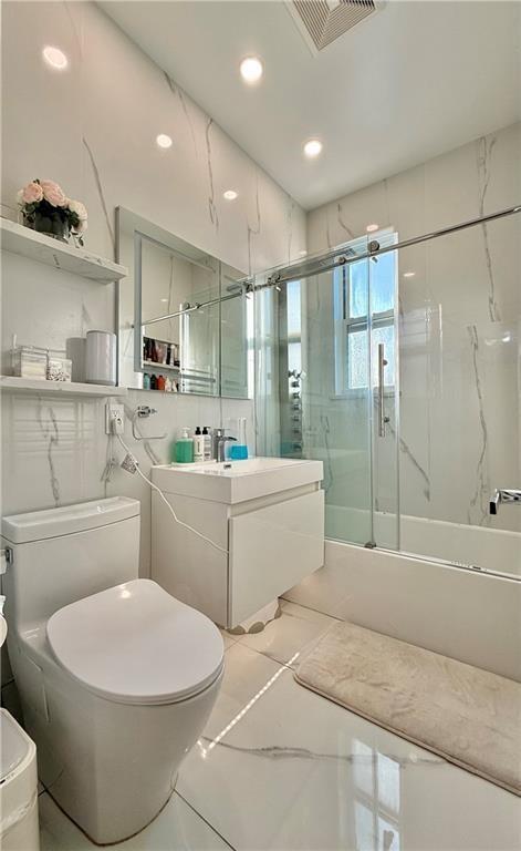 full bathroom featuring toilet, vanity, visible vents, marble finish floor, and a marble finish shower