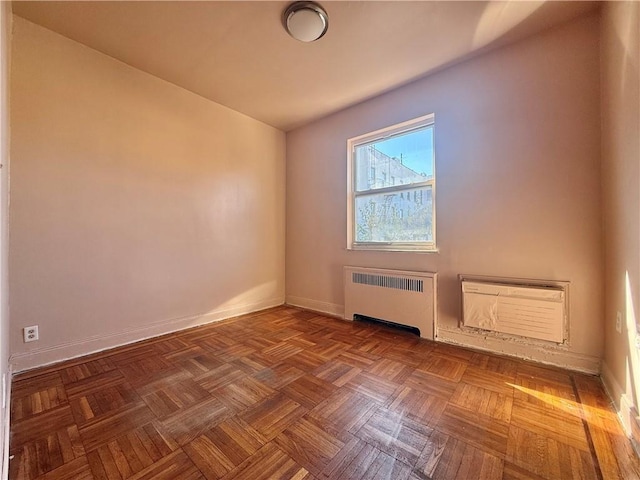 bonus room with parquet flooring, radiator heating unit, and a wall mounted AC