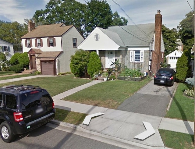 bungalow-style home featuring a garage and a front lawn