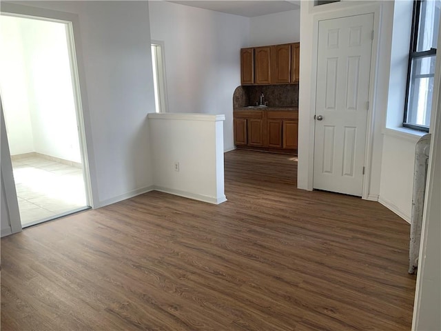 unfurnished room featuring sink and dark wood-type flooring