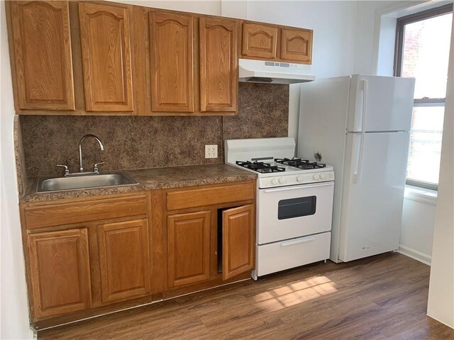 1738 79th St, Brooklyn, NY 11214 - kitchen with white appliances, a sink, under cabinet range hood, tasteful backsplash, and dark wood-style flooring