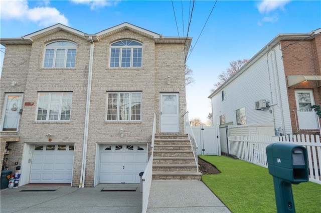 view of front of home featuring a front yard, a garage, and a wall unit AC