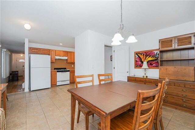 dining area with light tile patterned floors and an inviting chandelier