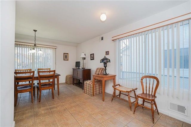 dining space featuring light tile patterned floors and an inviting chandelier