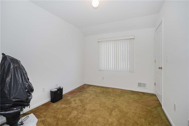 empty room featuring carpet floors and lofted ceiling