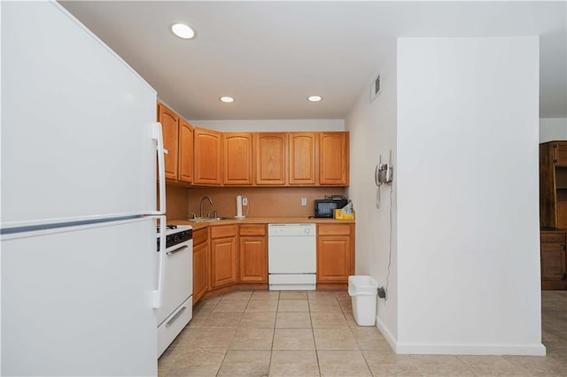 kitchen with sink, light tile patterned floors, and white appliances