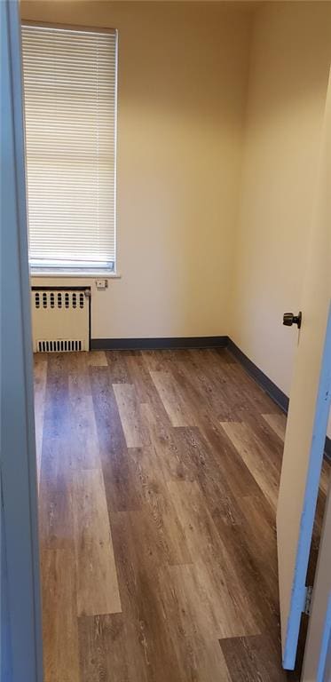 empty room with hardwood / wood-style floors and radiator