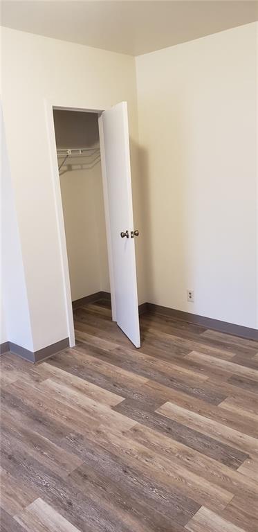 unfurnished bedroom featuring dark hardwood / wood-style floors and a closet