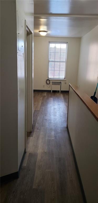 hallway featuring dark wood-type flooring and radiator heating unit