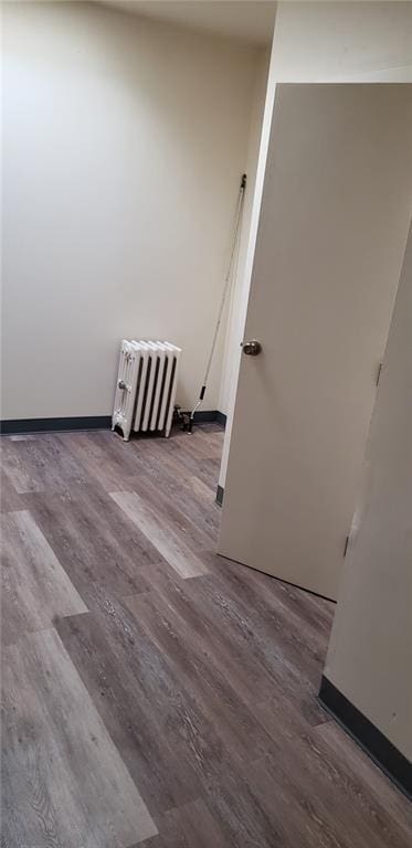 unfurnished room featuring wood-type flooring and radiator