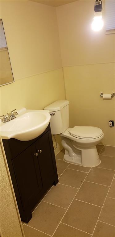 bathroom featuring tile patterned floors, vanity, and toilet