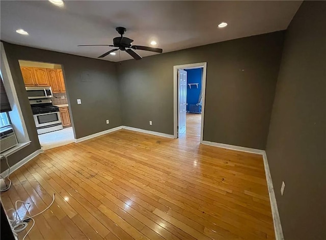 unfurnished living room featuring light wood finished floors, baseboards, a ceiling fan, and recessed lighting