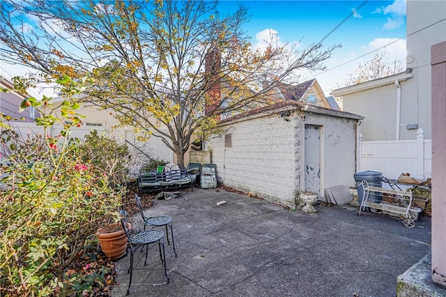 view of patio featuring fence and an outdoor structure