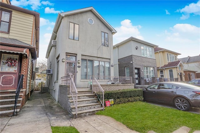 multi unit property featuring stucco siding and a front lawn