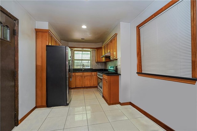 kitchen featuring stainless steel appliances, tasteful backsplash, sink, and light tile patterned floors