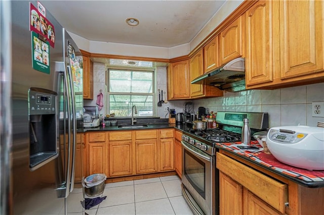 kitchen with appliances with stainless steel finishes, sink, light tile patterned floors, and backsplash