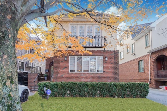 view of side of home with a yard, brick siding, and concrete driveway