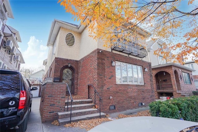 view of front of home featuring brick siding, crawl space, and stucco siding