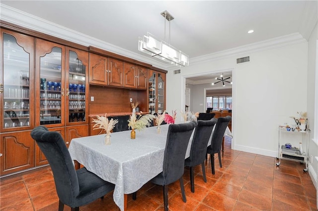 dining room with ceiling fan, dark tile patterned floors, and ornamental molding