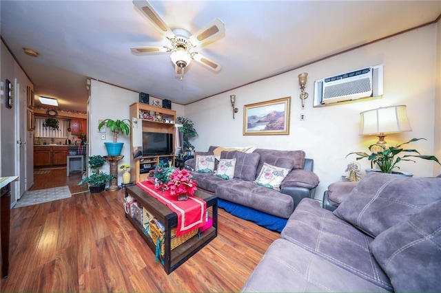 living room with a wall mounted air conditioner, hardwood / wood-style flooring, and ceiling fan