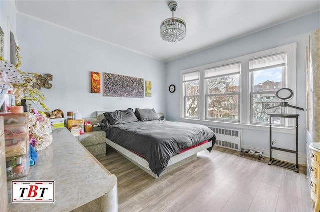 bedroom featuring hardwood / wood-style flooring and radiator